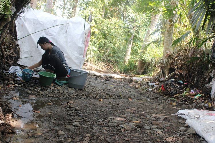 Seorang warga di Desa Cisalak, Kec. Cibeber, Kab. Cianjur, Jawa Barat tengah mencuci di cerukan di Kali Cisalak yang mengering, Minggu (21/07/019) akibat kemarau panjang dan dampak jebolnya tanggul irigasi Sungai Cikondang, CIbeber.
