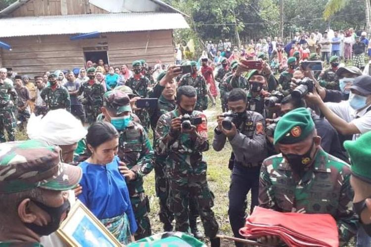 Dalimahu Talaohu, istri Praka Alif Nur Angkotasan (Baju biru) terus menangis saat mengikuti proses pemakaman suaminya di Desa Pelauw, Kecamatan Pulau Haruku, Kabupaten Maluku Tengah, Kamis sore (20/5/2021)