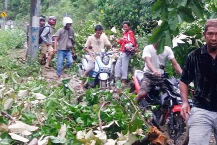 Sejumlah pengendara motor melewati jalur yang terkena longsor di pesisir selatan Bone Bolango, Gorontalo