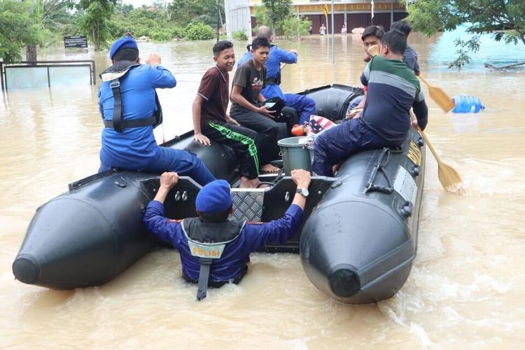 Petugas Ditpolairud Polda Riau membantu evakuasi warga korban banjir di Pekanbaru. 