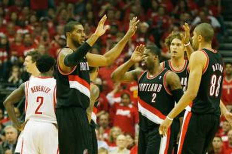 Pemain Portland Trail Blazers LaMarcus Aldridge (kiri) melakukan tos dengan rekan satu timnya setelah meraih poin pada babak pertama laga kedua babak play-off Wilayah Barat melawan Houston Rockets di Toyota Center, Rabu (23/4/2014).