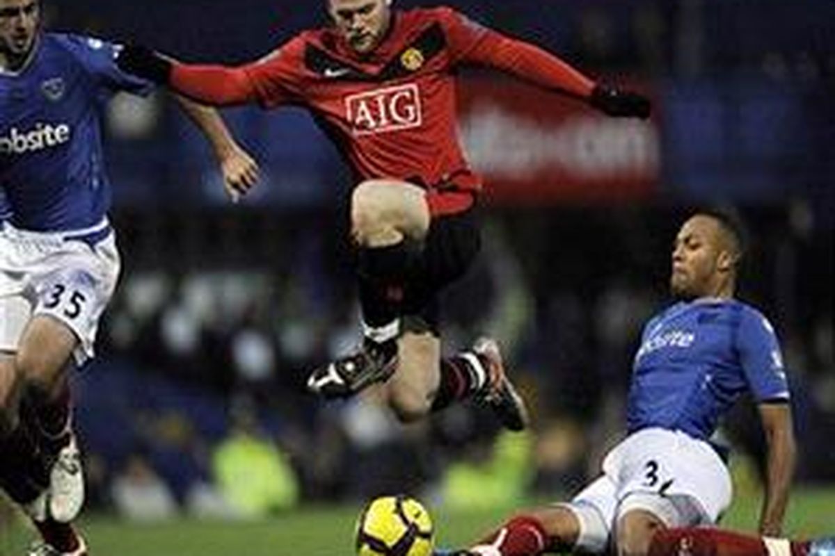 Penyerang Manchester United, Wayne Rooney (tengah) mencoba melewati adangan pemain Portsmouth, dalam lanjutan Premier League, Sabtu (28/11).