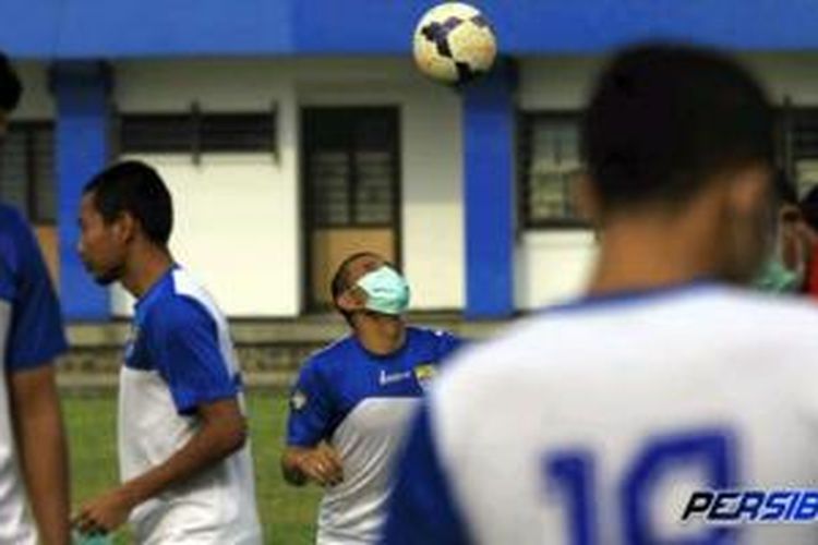 Para pemain Persib Bandung berlatih mengenakan masker untuk mengantisipasi debu vulkanik erupsi Gunung Kelud, Jumat (14/2/2014). 
