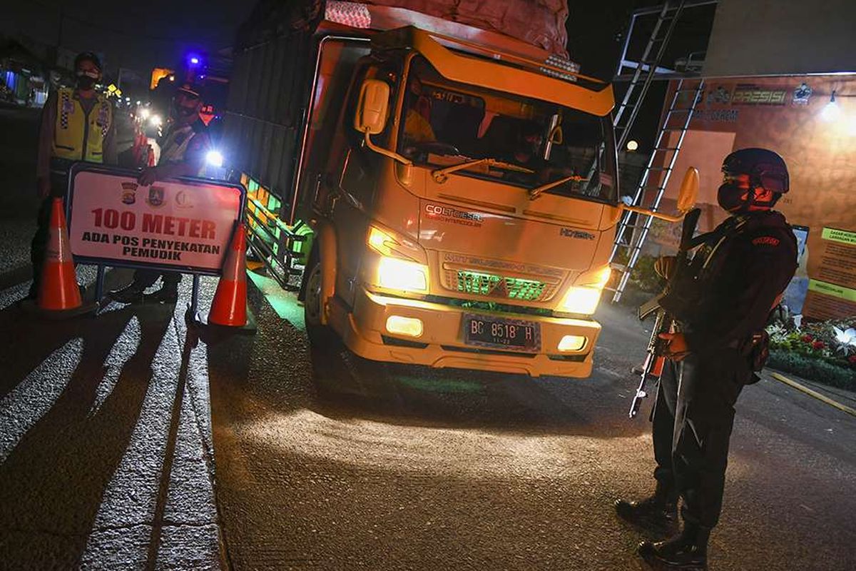 Petugas kepolisian memeriksa dokumen pengendara yang melintas dari arah Jakarta menuju Pulau Sumatera melalui Pelabuhan Merak di pintu Gerbang Tol Merak, Banten, Kamis (6/5/2021) dini hari. Pemeriksaan tersebut terkait larangan mudik lebaran 2021 yang dimulai dari tanggal 6 hingga 17 Mei sebagai upaya mengantisipasi risiko peningkatan kasus penularan COVID-19 jelang perayaan Hari Raya Idul Fitri 1442 H.