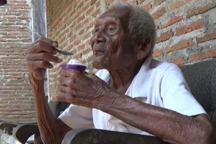 Suparman Sodimedjo atau Mbah Gotho tengah memakan es krim di rumahnya di Klaten, Jawa Tengah, Senin (29/8/2016).