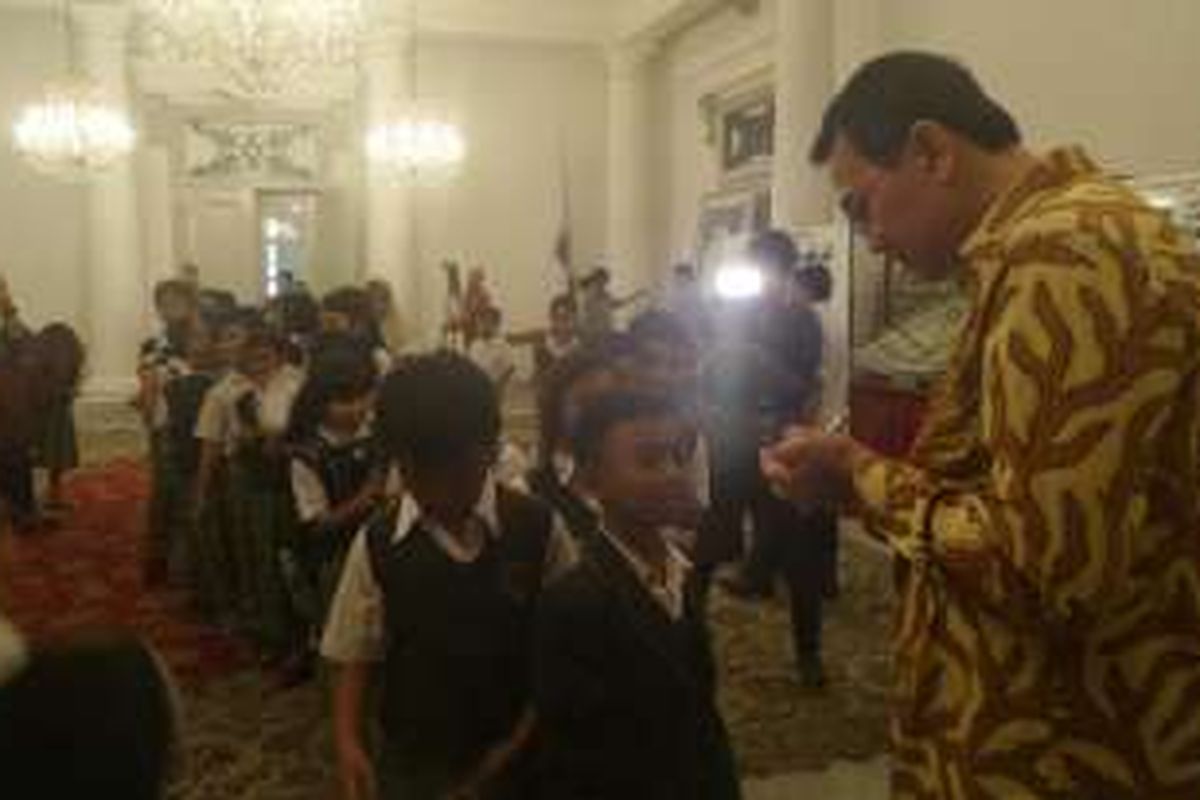 Gubernur DKI Jakarta Basuki Tjahaja Purnama membubuhkan tanda tangan di kartu namanya untuk diberikan kepada anak-anak sekolah dasar. 