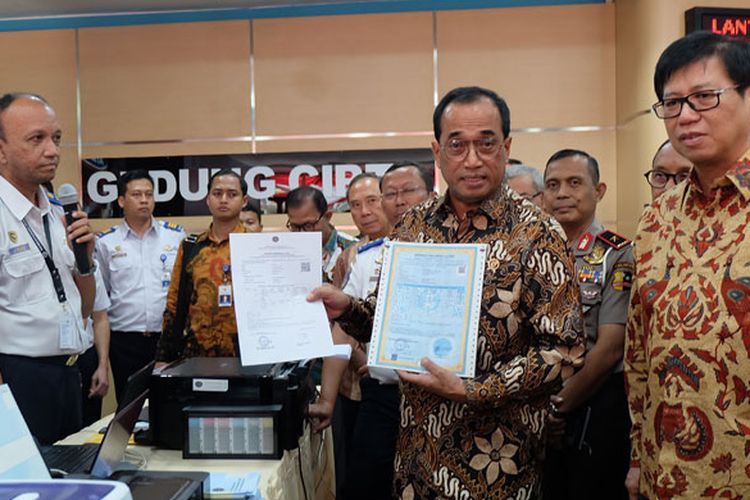 Menteri Perhubungan Budi Karya Sumadi didampingi Ketua AISI Johanes Loman menunjukkan perbedaan SRUT dan E-SRUT