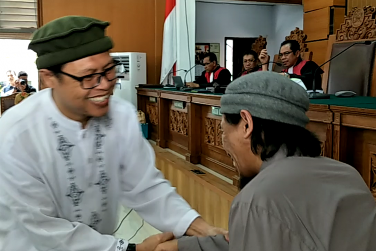 Pimpinan kelompok Jemaah Ansharut Daulah (JAD) Zainal Anshori (baju putih, kiri) yang menjadi saksi menyalami terdakwa peledakan bom Thamrin, Aman Abdurrahman, dalam persidangan di Pengadilan Negeri Jakarta Selatan, Jumat (9/3/2018).