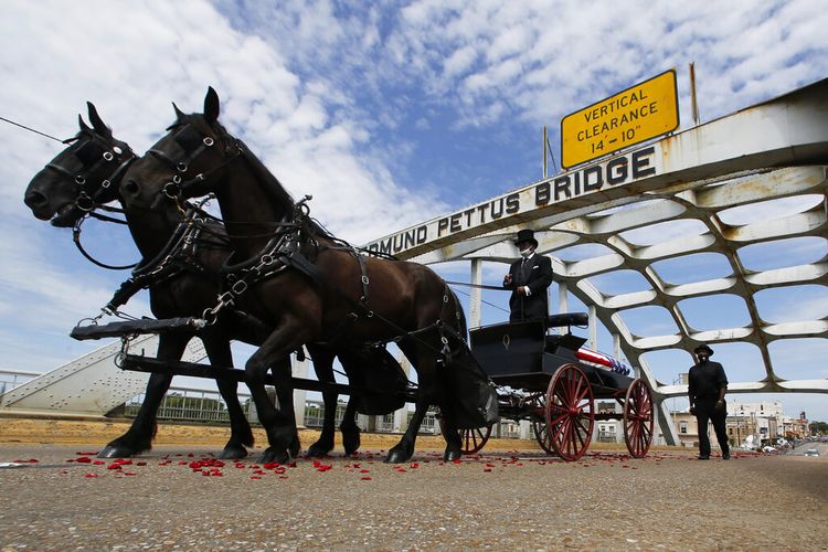 A lone caisson drawn by two black horses carried the body of leading figure of the US civil rights movement, John Lewis, across the Edmund Pettus Bridge on Sunday.