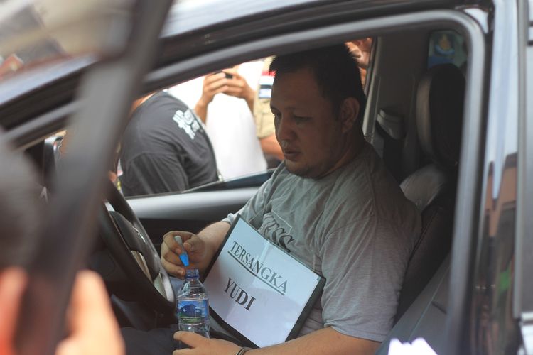 Yudi Tama Redianto (50) pelaku pembunuhan PNS Kementerian Pu Aprianita (50) saat sedang melakukan rekontruksi di kediaman korban. Pelaksanaan rekontruksi pun dijaga ketat oleh piham kepolisjan untuk menghindari amukan keluarga korban, Senin (2/12/2019).