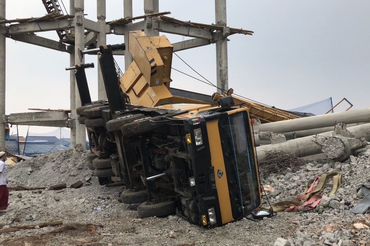 Truk crane proyek milik PDAM Asata Tirta terguling dan menimpa rumah warga di Jalan Mawar, Pancoran Mas, Kota Depok, Jawa Barat pada Jumat (15/10/2021) siang.