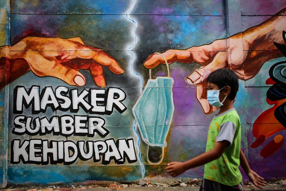 Seorang bocah melintas di depan mural tentang penggunaan masker di Kota Tangerang, Banten, Minggu (21/12/2020). Mural tersebut dibuat sebagai edukasi kepada masyarakat untuk selalu menggunakan masker guna mencegah penyebaran COVID-19. ANTARA FOTO/Fauzan/aww.