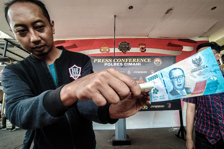 Polisi menunjukkan uang palsu yang diproduksi pasangan suami istri di Kota Bandung, Jawa Barat, Rabu (29/5/2024).