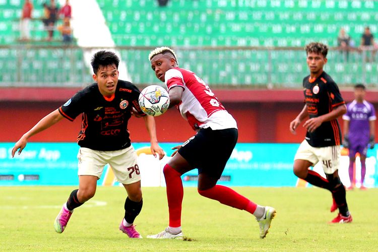 Pemain Persija Jakarta Witan Sulaeman dijaga ketat pemain Madura United Hugo Gomes saat pertandingan pekan ke-27 Liga 1 2022-2023 yang berakhir dengan skor 0-0 di Stadion Gelora Ratu Pamelingan Pamekasan, Minggu (26/2/2023) sore.