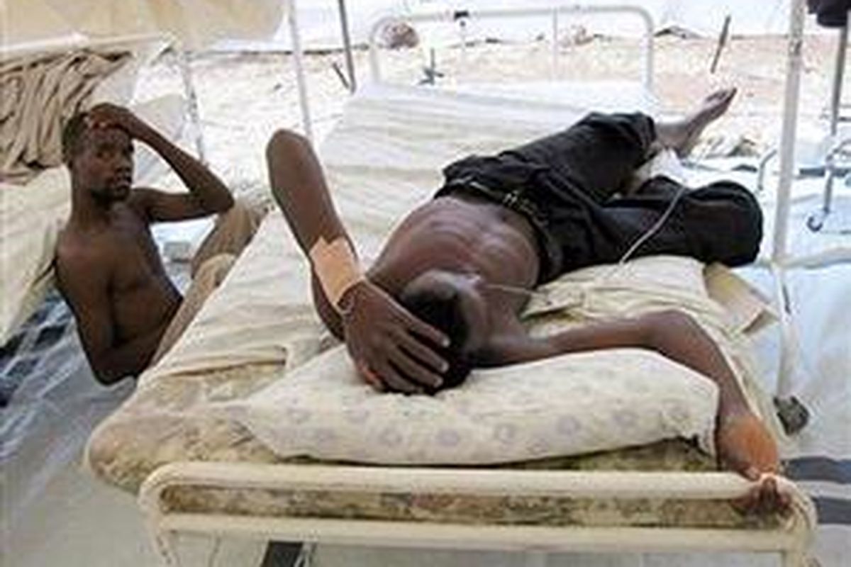 Dua pria Zimbabwe beristirahat di sebuah tenda rehidrasi kolera rumah sakit Musina, perbatasan Zimbabwe-Afrika Selatan, 11 Desember 2008