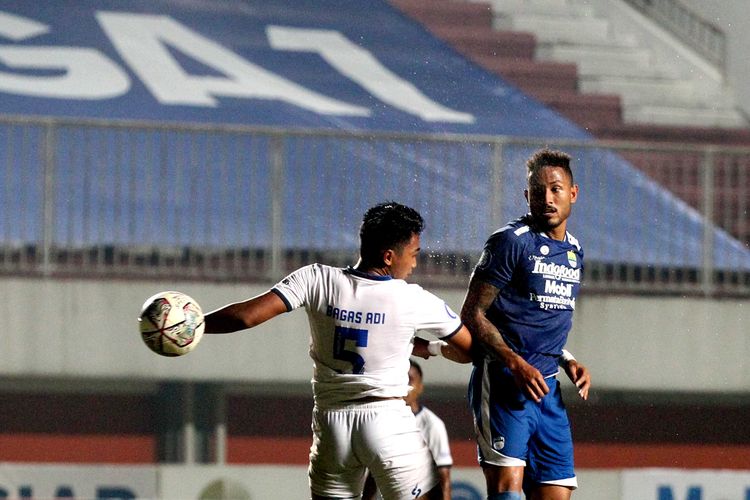 Pemain asing Persib Bandung Wander Luiz duel bola udara dengan pemain Arema FC Bagas Adi pada pertandingan pekan 14 Liga 1 2021-2022 yang berakhir dengan skor 0-1 di Stadion Maguwoharjo Sleman, Minggu (28/11/2021) malam. 