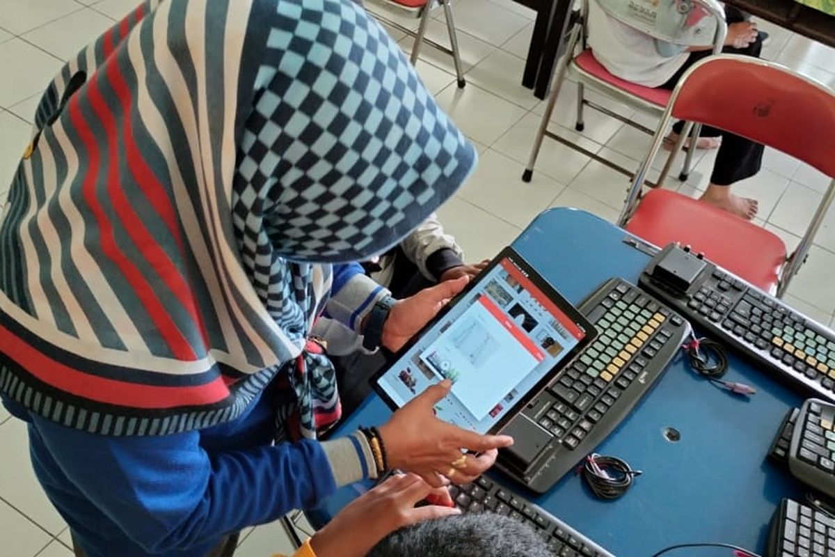 Seorang perempuan tengah mencoba aplikasi I-Chat. 