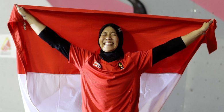 Atlet panjat tebing Indonesia Aries Susanti Rahayu mengibarkan Bendera Merah Putih setelah berhasil meraih medali emas pada kategori speed Asian Games 2018 di Arena Panjat Tebing Jakabaring Sport City, Palembang, Sumatera Selatan, Kamis (23/8/2018).