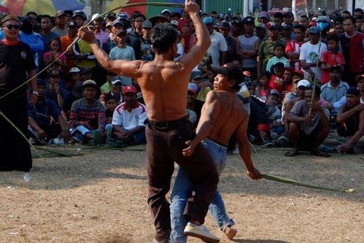 Dua pria saling cambuk dalam pertunjukan kesenian tiban di lapangan Desa Kerjo, Kecamatan Karangan, Kabupaten Trenggalek, Minggu (13/10/2019). Tiban juga berkembang di daerah lain selain Tulungagung, salah satunya Trenggalek.