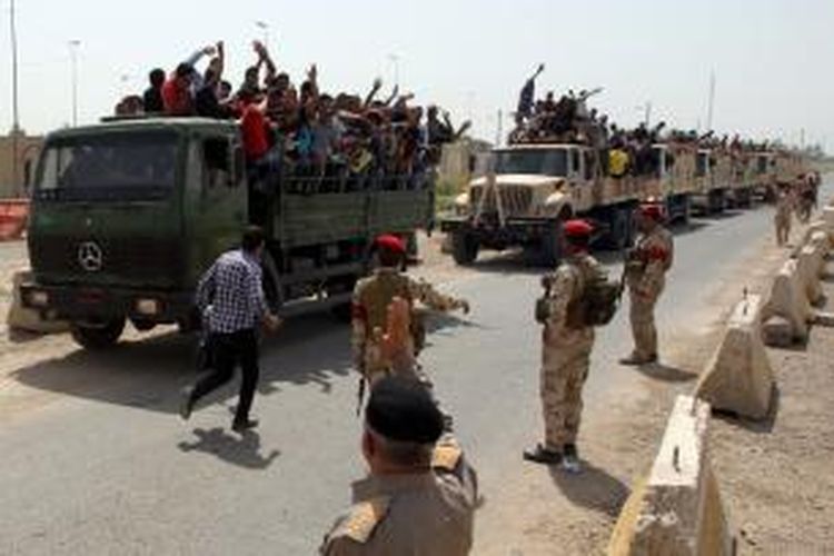 Ratusan warga Irak yang mendaftarkan diri menjadi sukarelawan untuk membendung gerak maju kelompok militan ISIS menuju ibu kota Baghdad, menaiki sejumlah truk militer setelah selesai mendaftarkan diri.