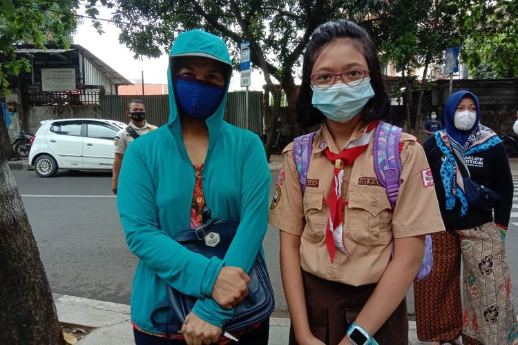 Orangtua murid, Yuli, dan putrinya, Keyla, setelah uji coba sekolah tatap muka di SDN Pondok Kelapa 05 Pagi, Jakarta Timur, Rabu (7/4/2021).