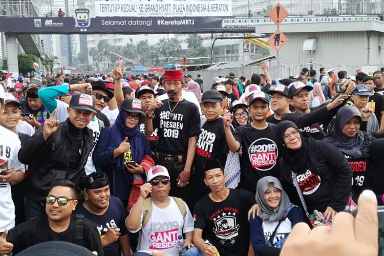 Sejumlah warga tampak memakai baju dan kaus #2019GantiPresiden di Bundaran HI, Jakarta, Minggu (29/4/2018).
