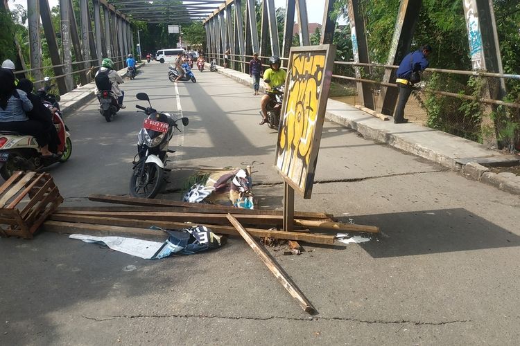Palang jembatan besi penghubung Kecamatan Bekasi Utara dan Bekasi Timur serta retakan kecil di mulut jembatan akibat struktur bawahnya diterjang arus Kali Bekasi saat banjir, Rabu (1/1/2020).