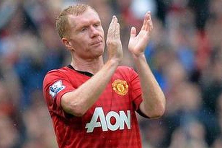 Gelandang Manchester United, Paul Scholes, memberi tanda sapaan kepada fans usai laga melawan Swansea City di Stadion Old Trafford, Minggu (12/5/2013). Ia menyatakan akan pensiun dari sepak bola.