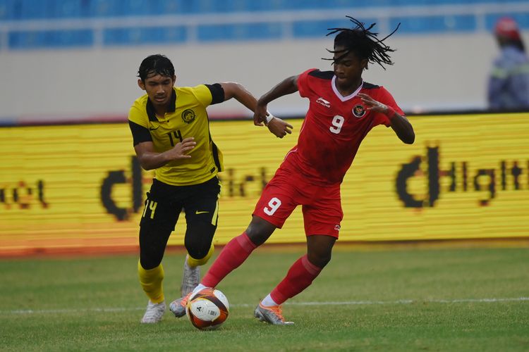 Pesepak bola Timnas Indonesia Ronaldo Kwateh (kanan) berebut bola dengan pesepak bola Timnas Malaysia Ahmad Zikri (kiri) dalam laga perebutan medali perunggu sepak bola SEA Games 2021 Vietnam di Stadion Nasional My Dinh, Hanoi, Vietnam, Minggu (22/5/2022). ANTARA FOTO/Aditya Pradana Putra/Pool/wsj.