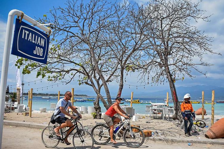 Dua orang wisatawan asing mengendarai sepeda di kawasan wisata Gili Trawangan, Desa Gili Indah, Kecamatan Pemenang, Tanjung, Lombok Utara, NTB, Rabu (8/8/2018). Pascagempa yang melanda daerah Lombok Utara, sebagian wisatawan asing memilih tetap tinggal di kawasan wisata Gili Trawangan.