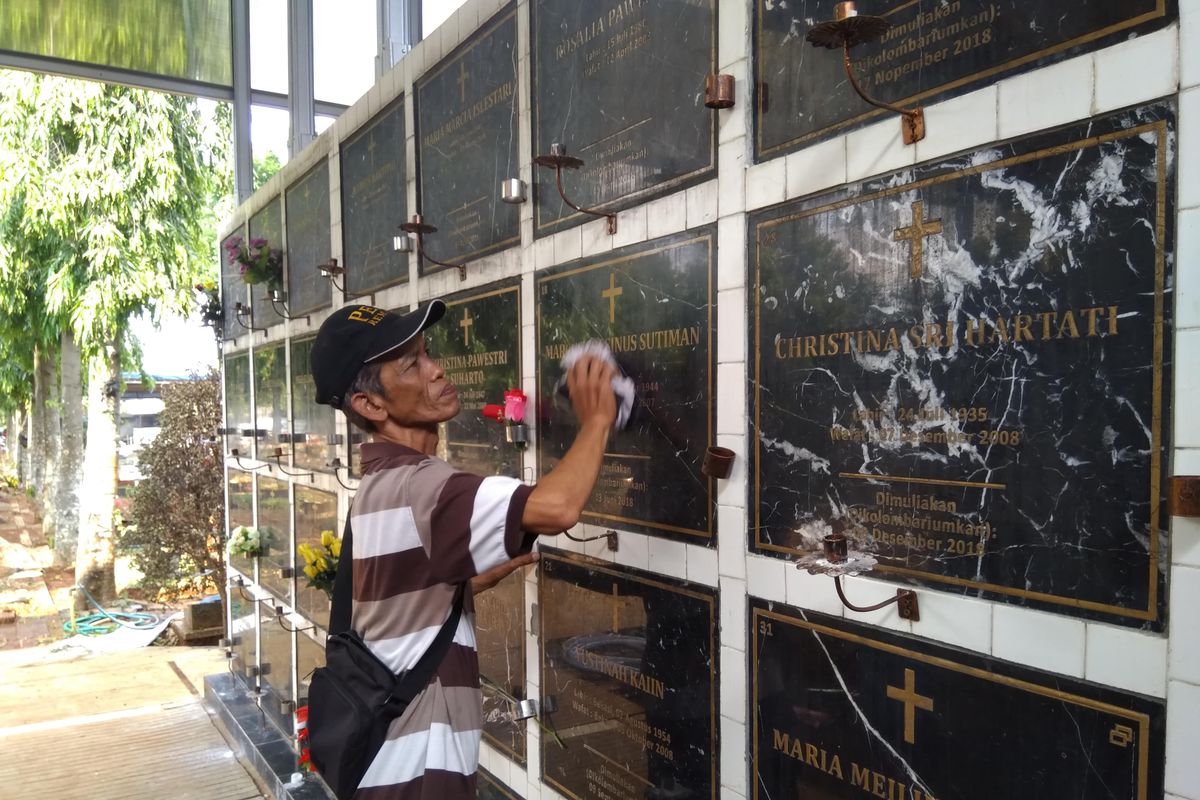 Markus Sulaeman sedang membersihkan keramik kolumbarium di Pemakaman Bitung Buaran, Pondok Melati, Bekasi