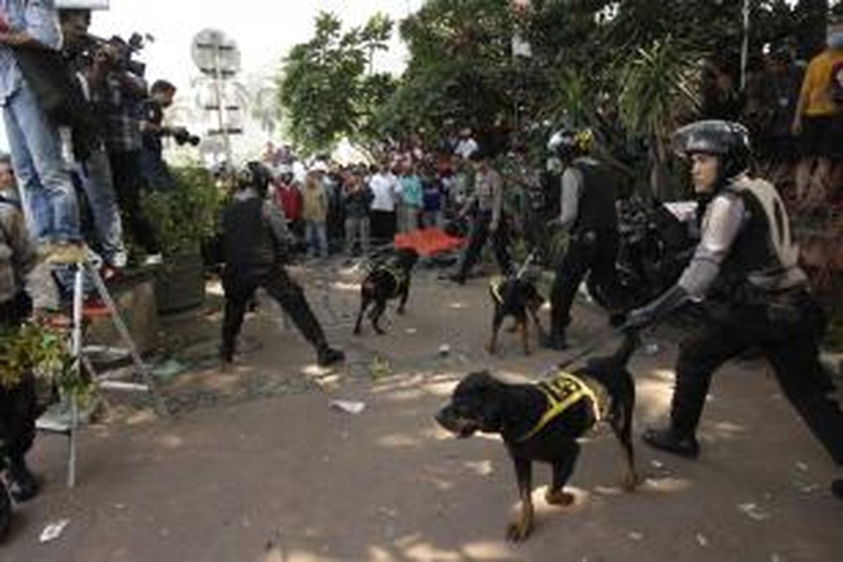 Polisi mengerahkan anjing dari unit K-9 untuk menghalau massa yang berusaha menerobos kawat berduri dan menuju Gedung Mahkamah Konsistusi di Jalan Medan Merdeka Barat, Jakarta, Kamis (21/8/2014).