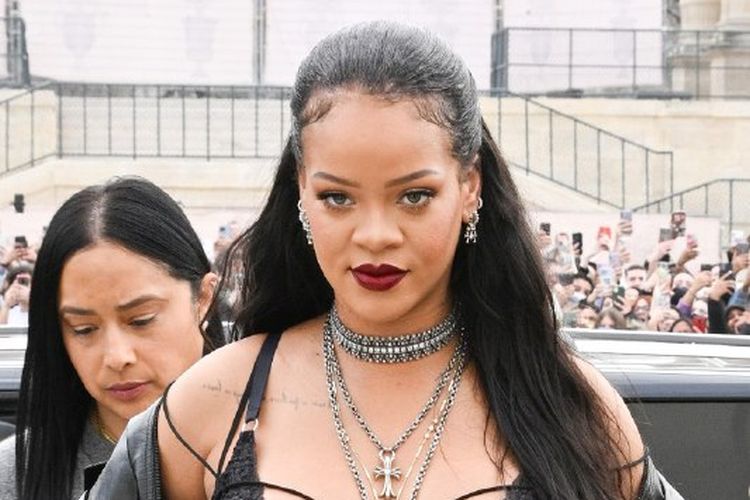 Rihanna tiba di fashion show Dior dengan memakai lingerie hitam sembari memamerkan baby bump-nya.