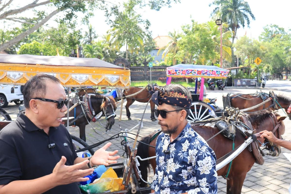 Bupati Tamba bersama salah satu kusir dokar saat berbagi kasih berupa bantuan sembako di depan Pura Jagatnatha, Jembrana, Sabtu (23/3/2024).