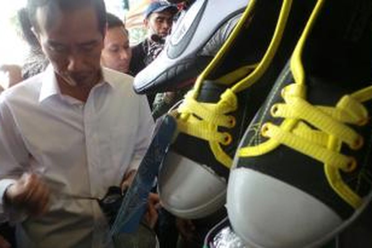 Gubernur DKI Jakarta Joko Widodo melihat sepatu yang dijual di lantai satu Pasar Blok G Tanah Abang, Jakarta Pusat, Selasa (25/2/2014). Di sana Jokowi membeli sepatu beragam ukuran dan kaus.