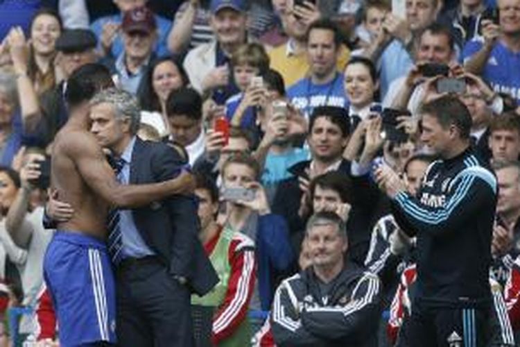 Didier Drogba (tak mengenakan baju) bersalaman dengan manajer Chelsea Jose Mourinho setelah ditarik keluar dalam laga terakhir Premier League melawan Sunderland di Stamford Bridge, Minggu (24/5/2015). Ini menjadi laga terakhir Drogba bersama Chelsea karena musim depan dia meninggalkan The Blues.