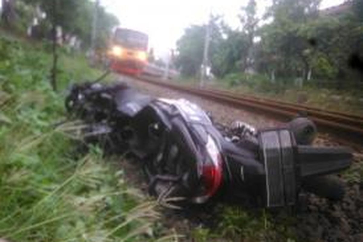 Sepeda motor milik Supardi rusak setelah terseret KRL Commuter Line di Palmerah, Minggu (5/4/2015).