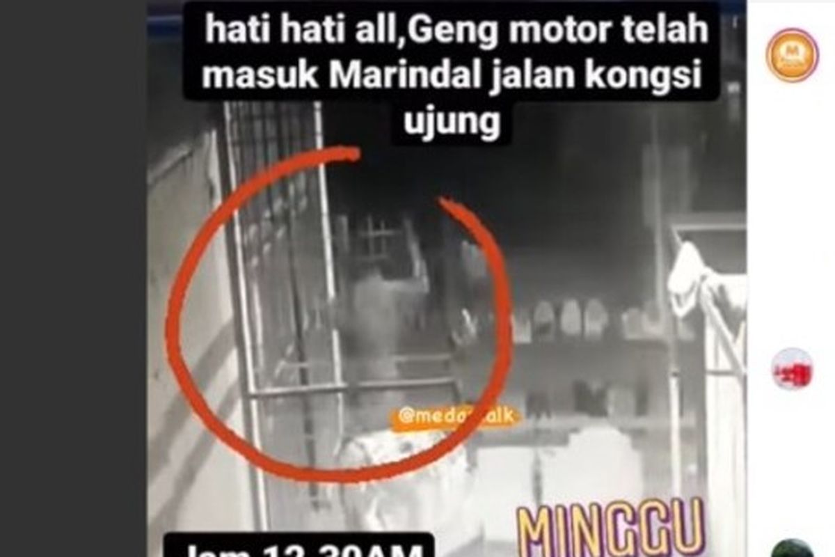 Tangkapan layar video viral memperlihatkan seorang pelaku geng motor yang memukuli pintu rumah warga di dekat lapangan bola Pasar XII, Desa Marindal II, Kecamatan Patumbak, Deli Serdang pada Minggu (21/11/2021) dinihari. Dalam kasus ini, personel Reskrim Polsek Patumbak mengamankan dua orang pelaku dengan barnag bukti berupa sebilah parang.