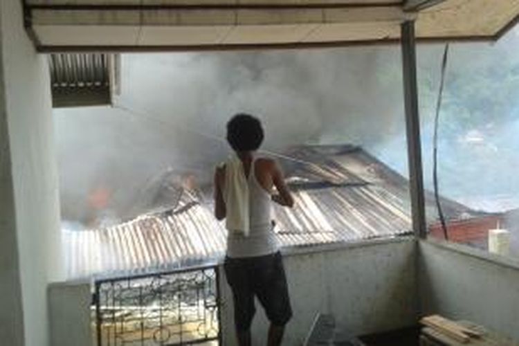 Sejumlah warga tampak sedang memadamkan api yang membakar sebuah rumah milik salah seorang anggota polisi di kawasan Batu Gaja, kecamatan Sirimau Ambon, Senin (29/9/2014).