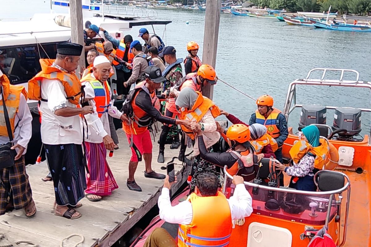 Petugas mengevakuasi sejumlah penumpang KMP Gerbang Samudra 2 yang kandas di perairan Selat Bali, Minggu (22/6/2025).