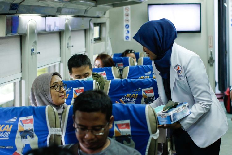 Petugas medis dari PT KAI DAOP 1 Jakarta membagikan masker pada calon penumpang kereta api di Stasiun Gambir, Jakarta, Jumat (31/1/2020). Pembagian masker gratis pada calon penumpang dalam rangka mengantisipasi penyebaran virus corona.