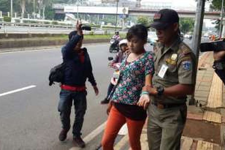 Satpol PP menggelandang perempuan yang berprofesi sebagai joki three in one  di Jalan Jenderal Gatot Subroto, Tanah Abang, Jakarta Pusat, Rabu (30/3/2016).