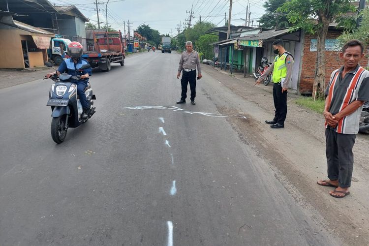 Petugas kepolisian saat melakukan olah TKP (Tempat Kejadian Perkara) insiden kecelakaan lalu lintas yang terjadi di Jalan Raya Desa Cangkir, Kecamatan Driyorejo, Gresik, Jawa Timur, Senin (5/12/2022).