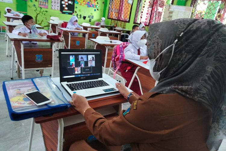Sampurna, Guru SDN 005/V Kuala Tungkal Tanjung Jabung Barat, Jambi, sedang melalukan pembelajaran blended learning. Siswa yang memilih belajar dari rumah difasilitasinya melalui Zoom.