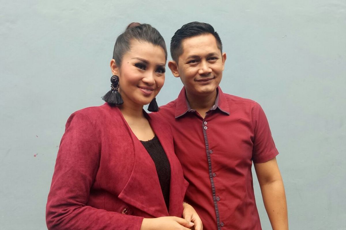 Fitri Carlina bersama suaminya, Hendra Sumendap, berpose untuk difoto oleh para peliput di kawasan Tendean, Jakarta Selatan, Jumat (26/1/2018). 