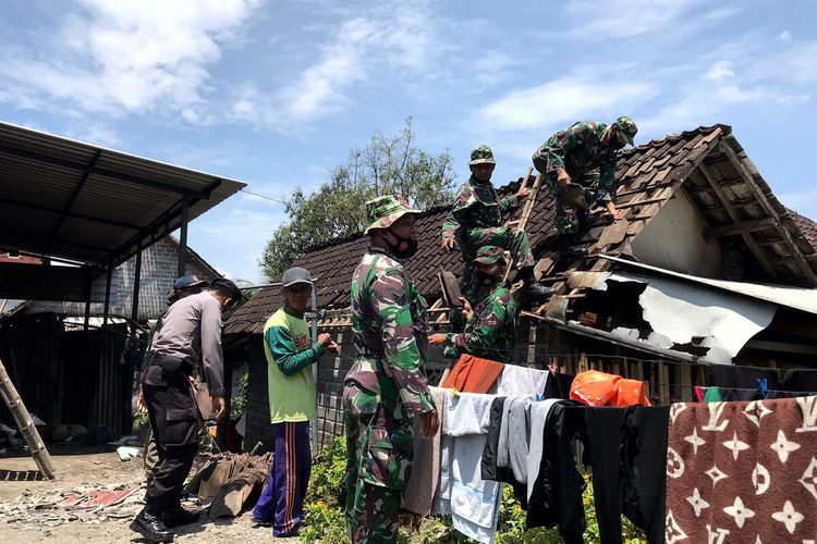 Personel TNI dan Polri bergotong royong memperbaiki atap rumah warga Desa Sumberasri, Kecamatan Nglegok, Kabupaten Blitar yang rusak diterpa angin puting beliung pada Senin malam, Selasa (29/3/2022)