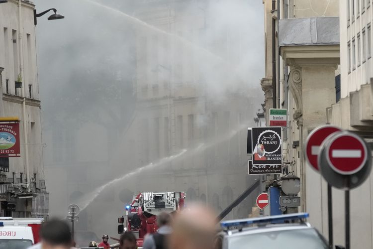Pemadam kebakaran menyemprotkan meriam air ke lokasi ledakan di Left Bank, Paris, Perancis, pada Rabu (21/6/2023). Saksi mata menyebutkan ada ledakan besar disusul kobaran api, dan sebagian bangunan roboh.