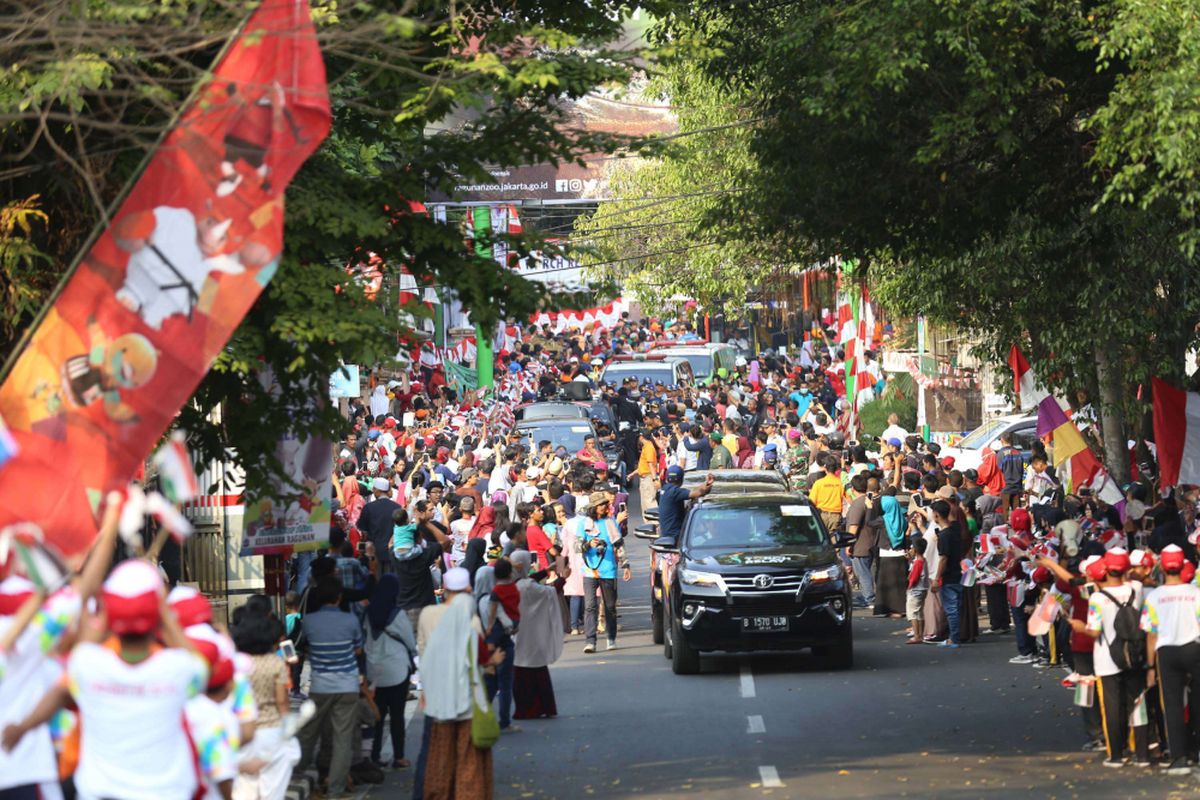 Sejumlah pelajar dan warga sekitar menyambut Kirab Obor saat Torch Relay Asian Games 2018 di Cilandak, Jakarta Selatan, Rabu (15/08/2018). Api Asian Games akan diarak mengelilingi 5 Kota dan 1 Kabupaten di Provinsi DKI Jakarta