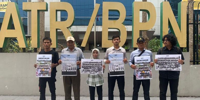 Sejumlah warga Air Bangis dan aktivis lingkungan memegang poster di depan gedung Kementerian ATR/BPN untuk memprotes perampasan lahan rakyat.