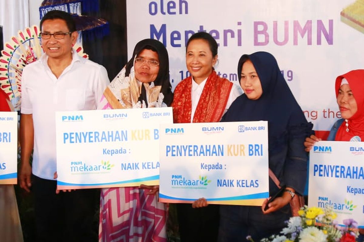 Direktur Bisnis Mikro Bank BRI Supari bersama Menteri BUMN Rini Soemarno berfoto bersama nasabah PNM Mekaar naik kelas yang menerima Kredit Usaha Rakyat (KUR) Mikro dari Bank BRI di Klungkung, Bali, Selasa (10/9/2019). 